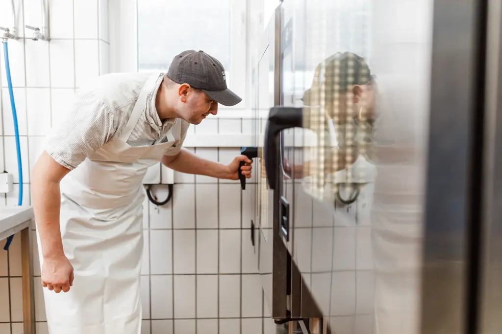 Michl Forster kontrolliert den Leberkäse im Ofen